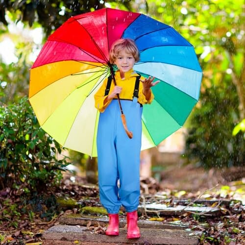 Child in rain with colorful umbrella and raincoat