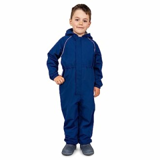 Child in blue coverall suit smiling.