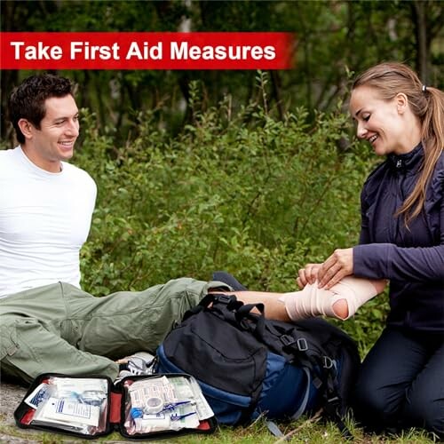 Two people practicing first aid outdoors with bandages and kit.