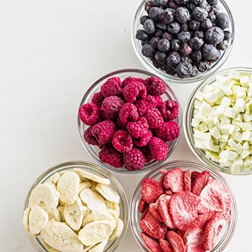 Bowls of assorted berries and fruits on a white surface.