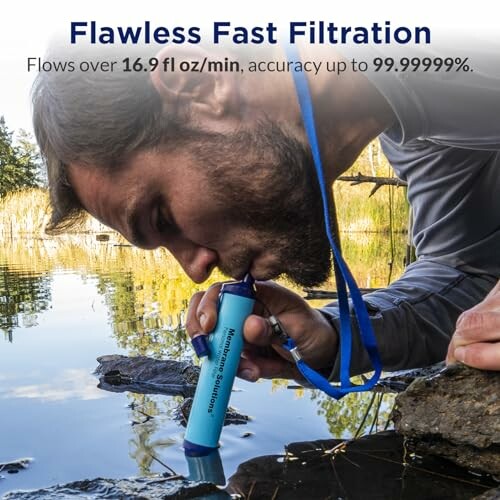 Person using a portable water filter by a lake.