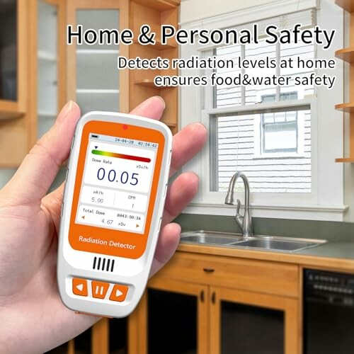 Hand holding a radiation detector in a kitchen setting.